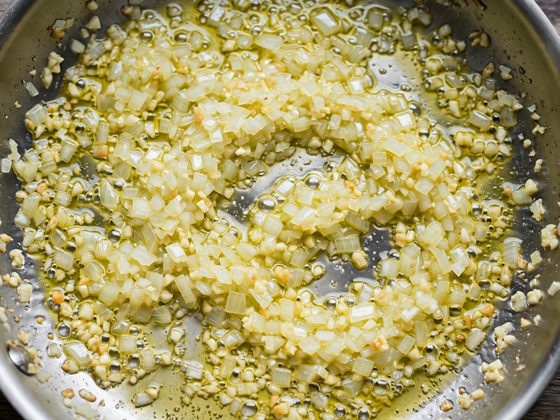 Zwiebel und Knoblauch werden in einer Pfanne angedünstet